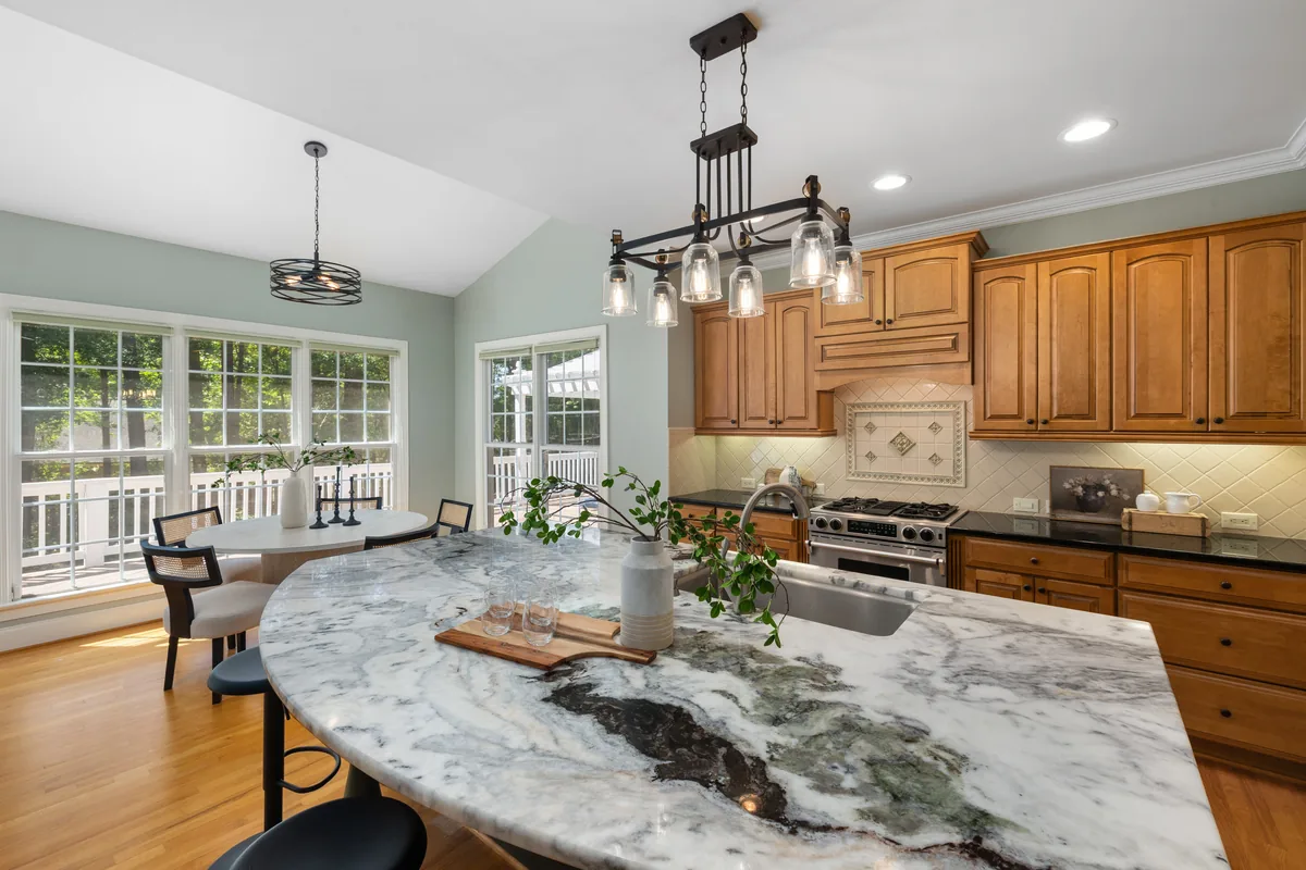 Finished kitchen with a large stone island and wood cabinetry